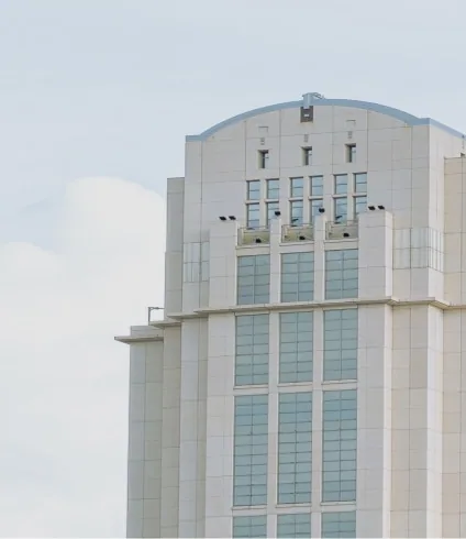 Tall white art deco building with arched top and vertical windows against overcast sky