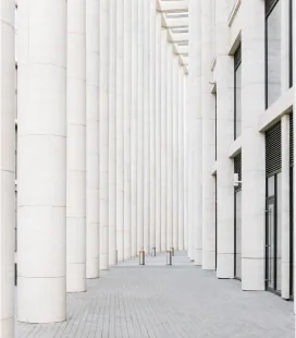 Corridor between tall white columns with light gray flooring
